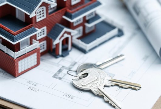 Villa house model, key and drawing on retro desktop (real estate sale concept)